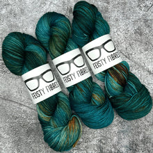 Load image into Gallery viewer, Three skeins of teal yarn with Feisty Fibres labels on a textured gray background