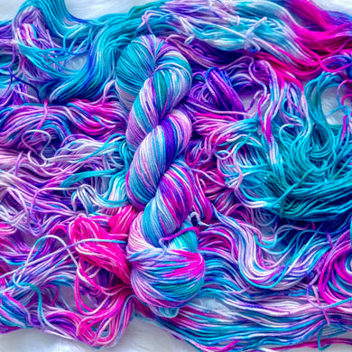 Colorful yarn skeins in pink, blue, and purple on a white background