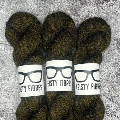 Three skeins of dark green yarn with 'Feisty Fibres' labels on a textured gray background