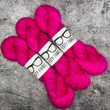 Load image into Gallery viewer, Three skeins of bright pink yarn with a label on a gray textured background
