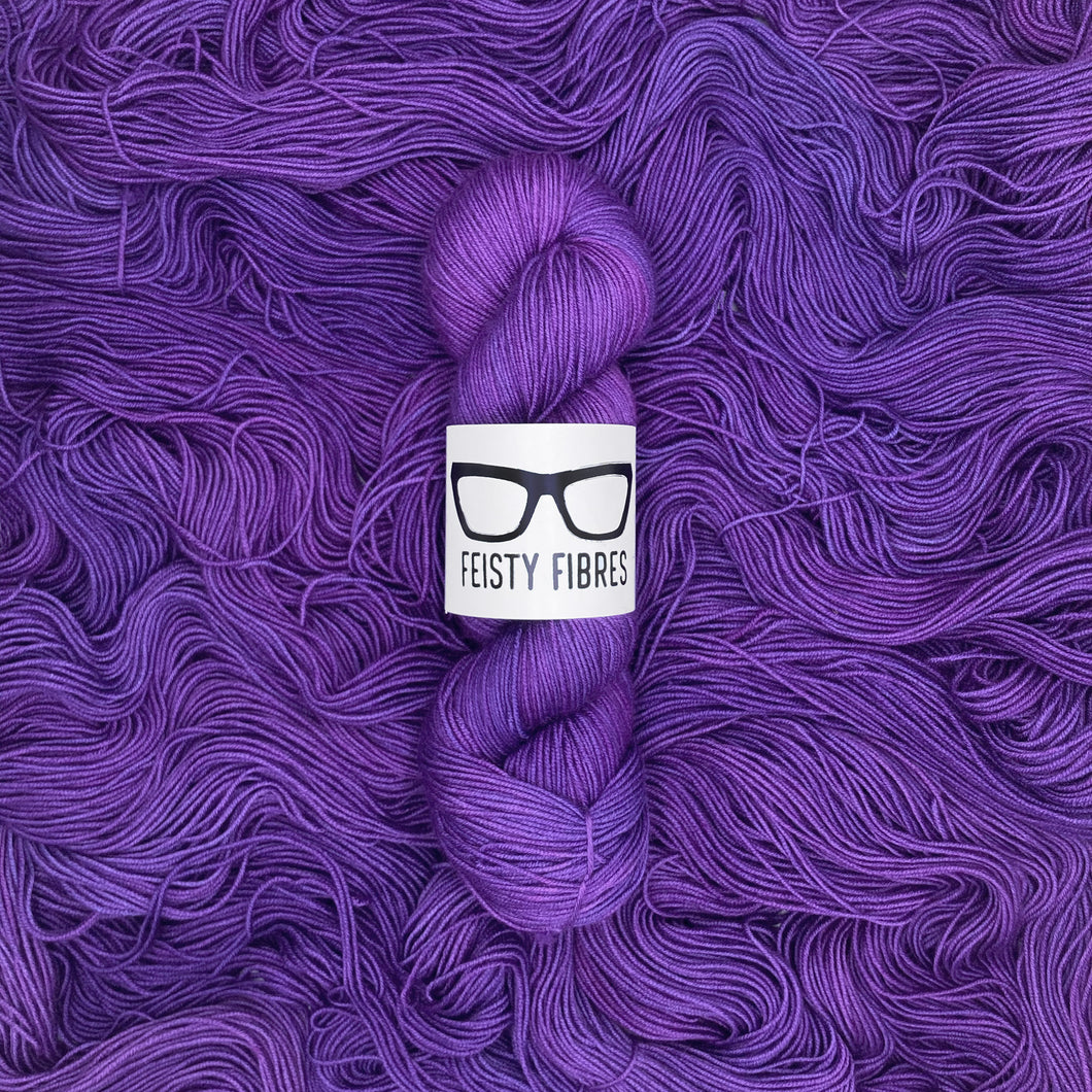 Purple yarn skein with a 'Feisty Fibres' label on a purple background