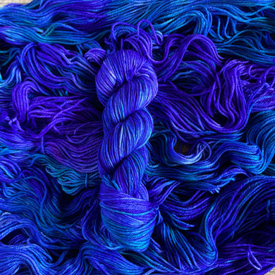 Purple and Blue yarn skein on a background of blue and purple yarn
