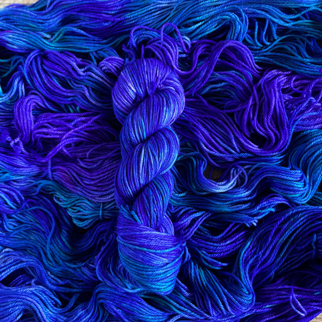 Purple and Blue yarn skein on a background of blue and purple yarn